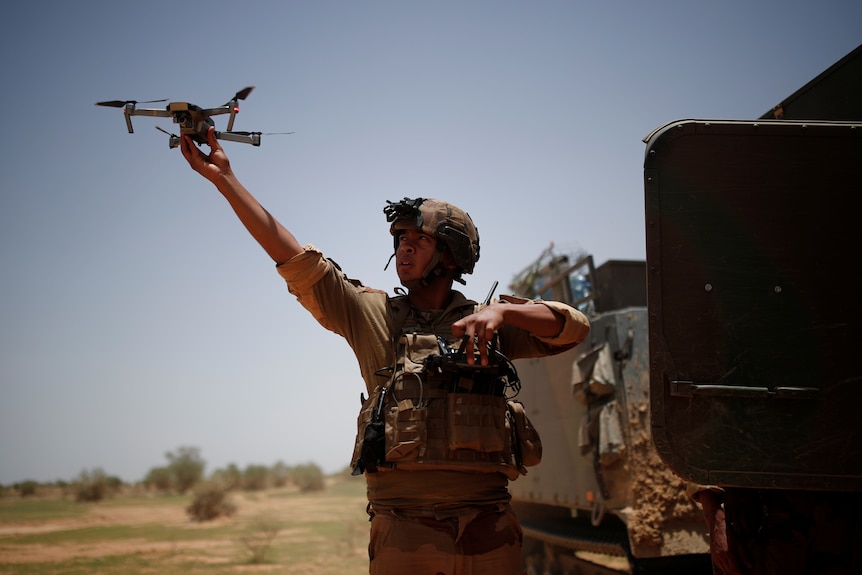 A soldier releases a drone.