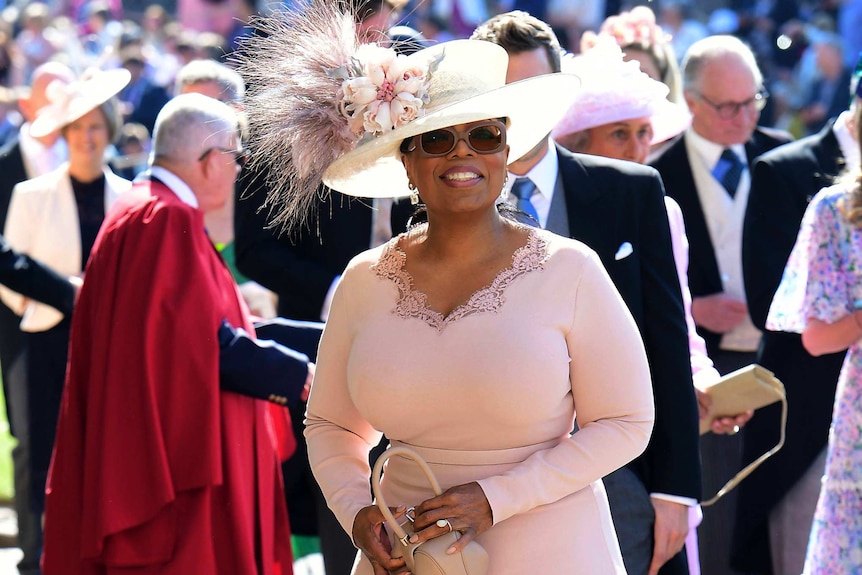 Oprah Winfrey sourit lorsqu'elle arrive à la Chapelle St George du château de Windsor.