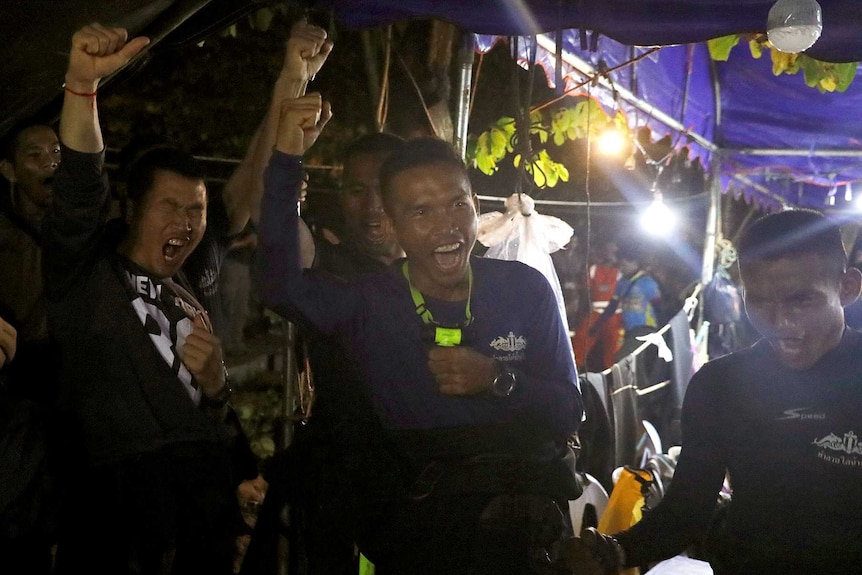 Rescuers yell and raise fists in triumph