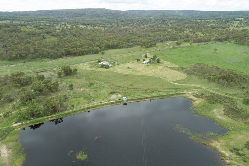 An aerial photo of a full dam and green paddocks
