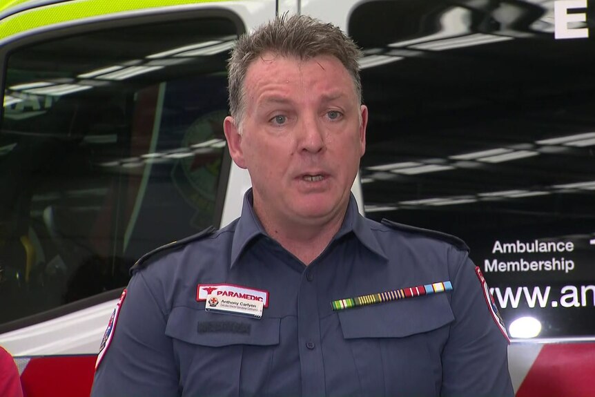 a man in a paramedics uniform in front of an ambulance