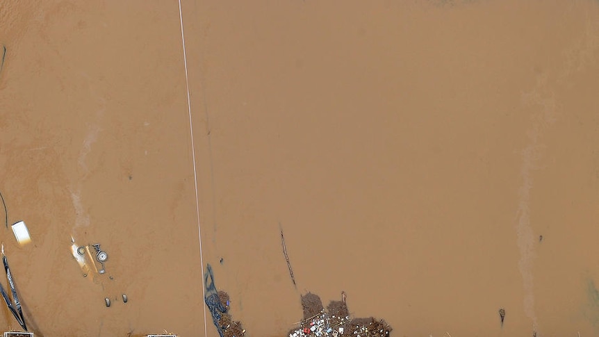 A railway crossing at Grantham is littered with debris and smashed cars from floodwaters on January 12, 2011.