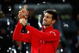 Serbia's Novak Djokovic holds the trophy after beating Andy Murray to win the Madrid Masters.