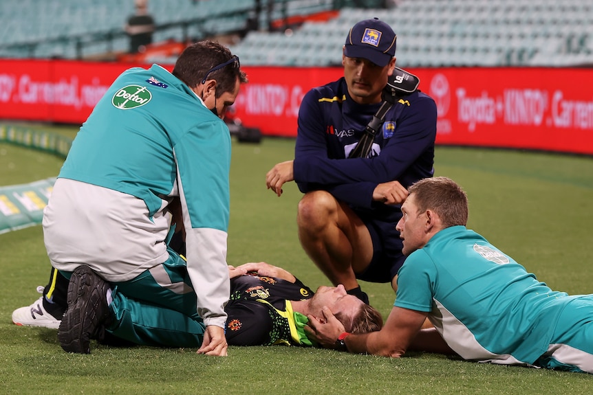 Le personnel médical s'occupe de Ste3ve Smith alors qu'il est allongé sur le terrain du SCG après avoir été blessé.