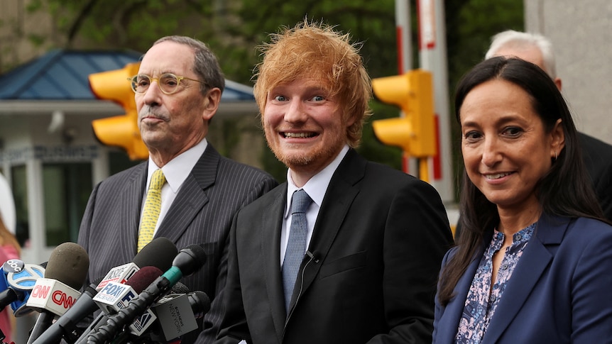 Singer Ed Sheeran smiles while speaking to the media outside a Manhattan court.