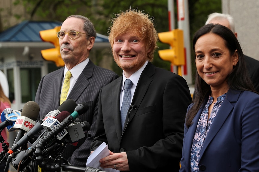 Singer Ed Sheeran smiles while speaking to the media outside a Manhattan court.