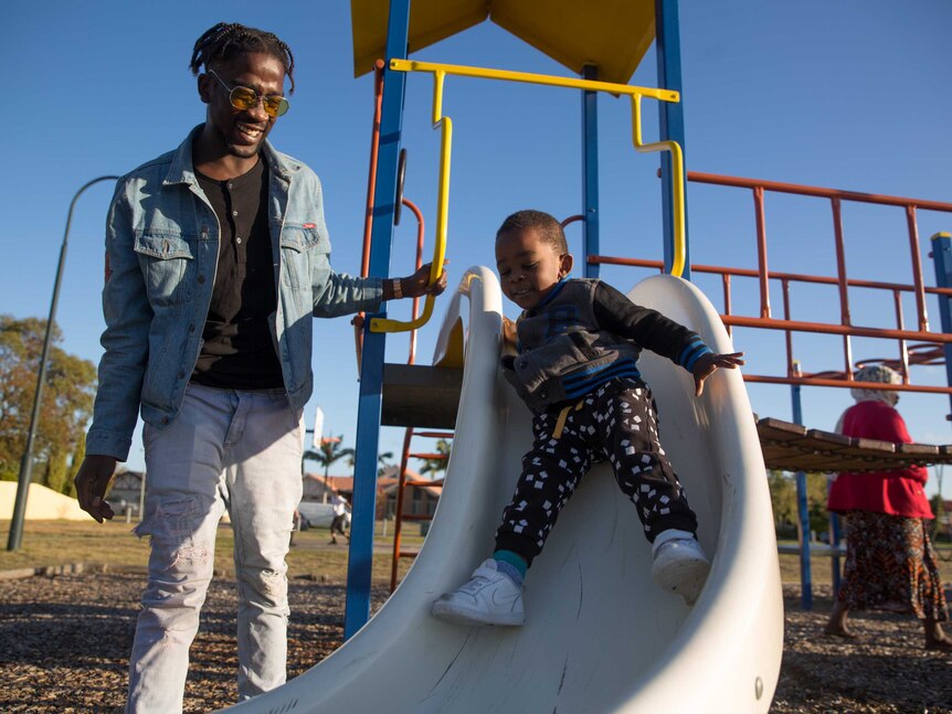 Mohamed plays with his youngest brother Mortada on a slide at the playground.