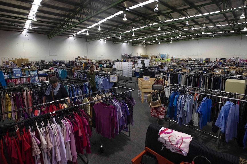 A large charity shop with racks of clothes