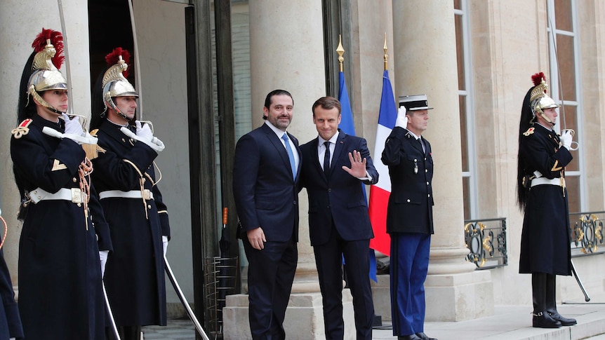 French President Emmanuel Macron, right, stands next to Lebanon's Prime Minister Saad Hariri at the entrance to Elysee Palace.