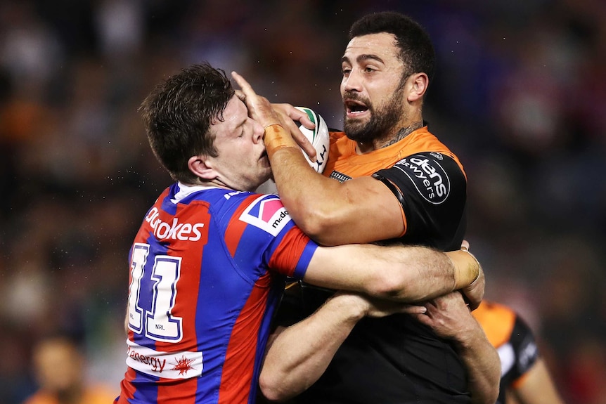 Ben Matulino is tackled by Lachlan Fitzgibbon during the Knights versus Tigers NRL match.