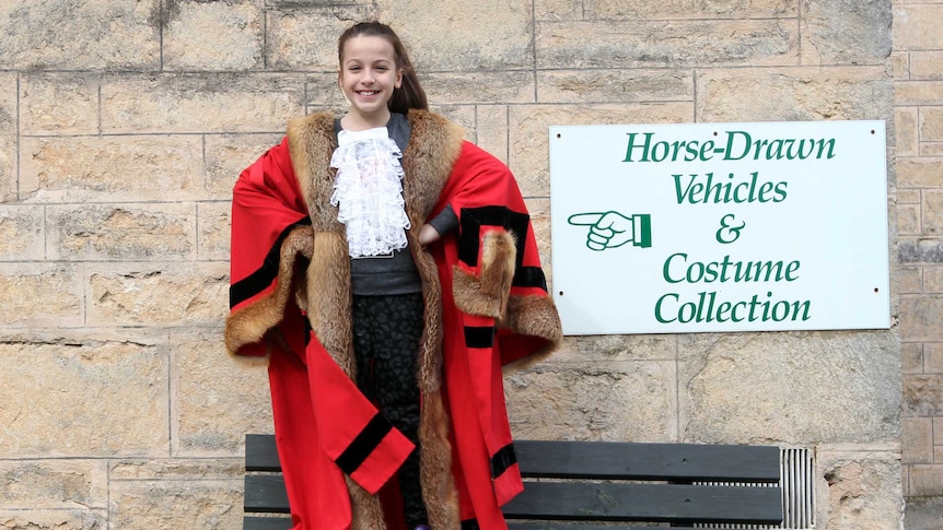 Young girl wears red mayoral robes