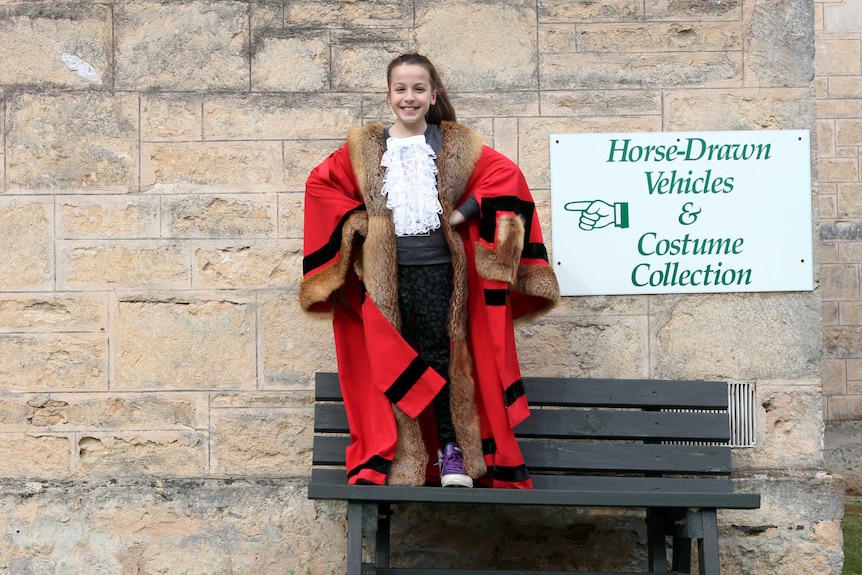 Young girl wears red mayoral robes