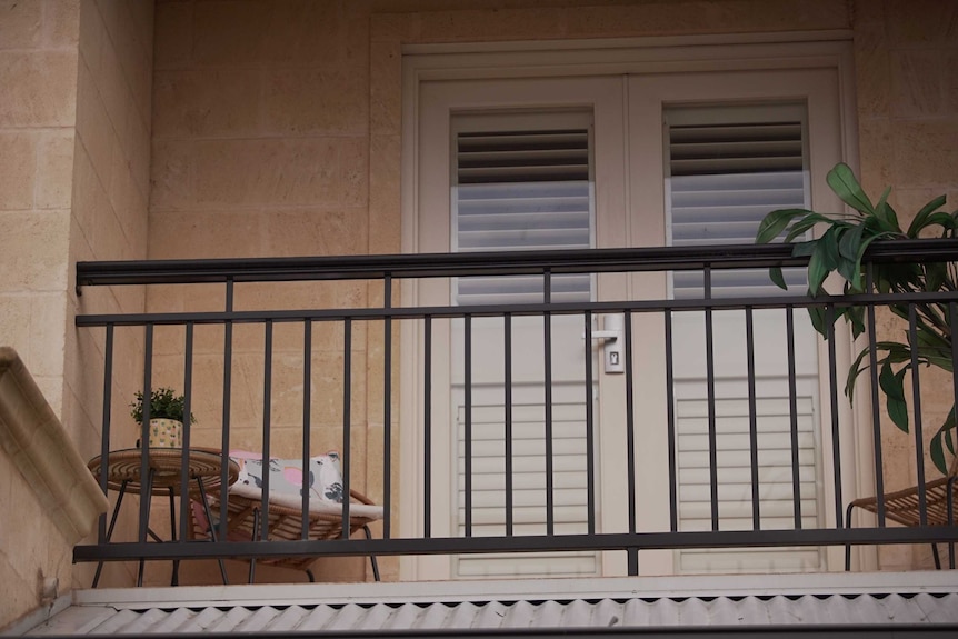 An upstairs balcony with outdoor furniture.