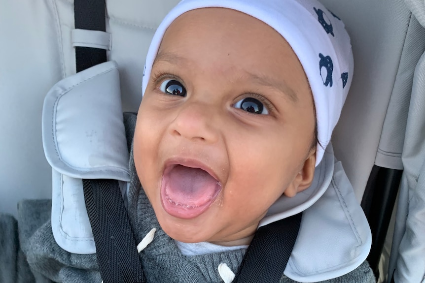 A baby in a bonnet and car seat