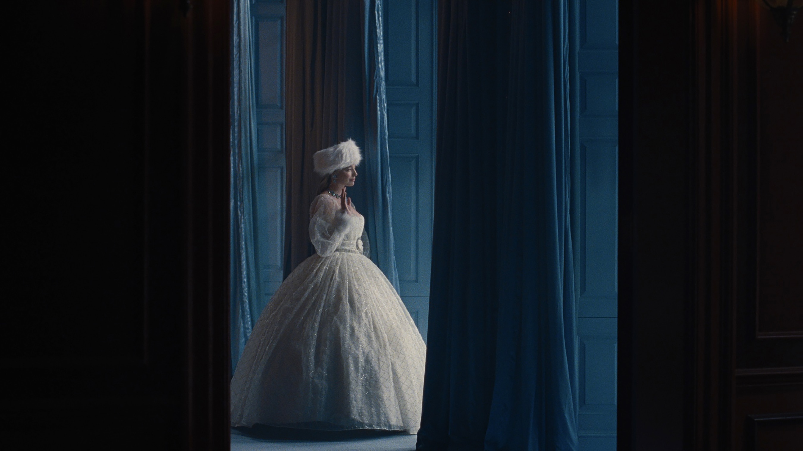 Una mujer con un vestido de novia blanco e hinchado camina por un bosque.