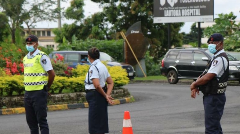 Fiji police officers guard the Lautoka hospital which has been shut off from the public after a patient died from COVID-19.