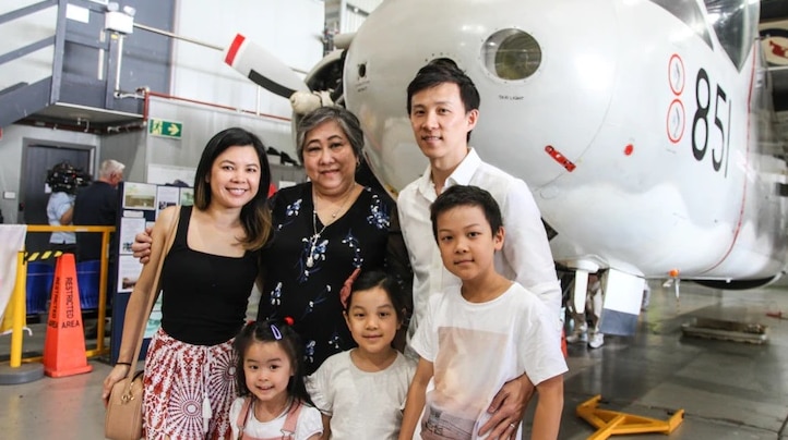 当年的越南难民梅红（Mai Hong）与家人在救了他们的851号S-2G反潜巡逻机前合影。