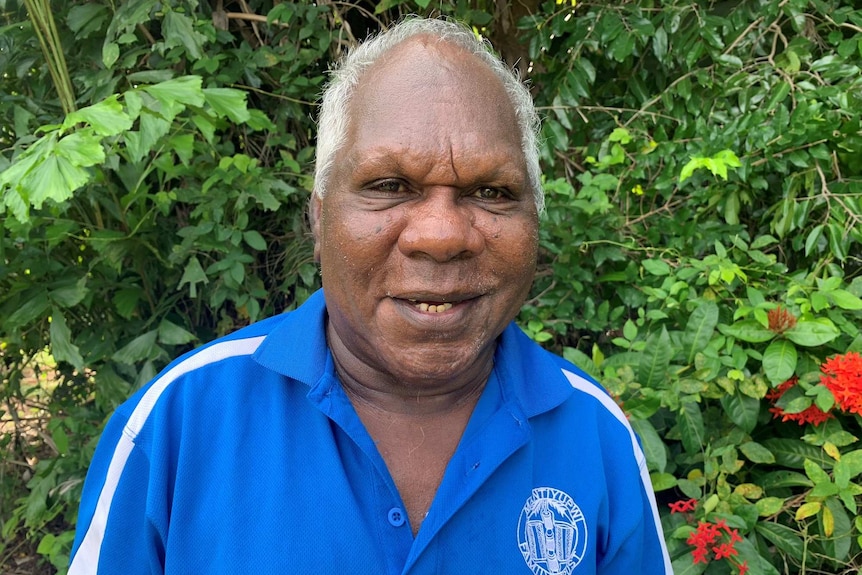 Gibson Farmer smiles at the camera from close range wearing a blue polo shirt.