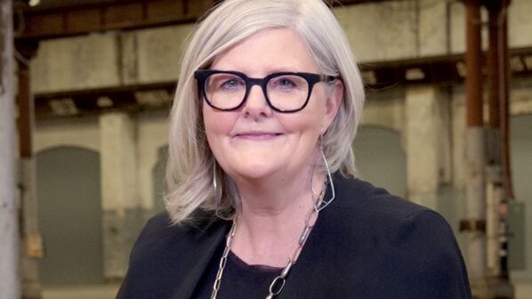 Sam Mostyn sits upright and smiles for a photo