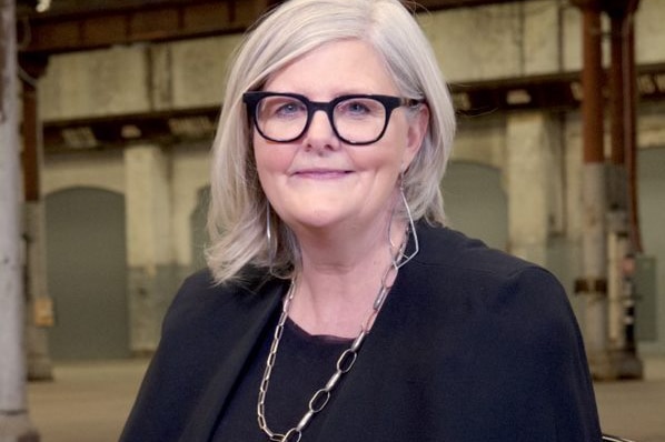 Sam Mostyn sits upright and smiles for a photo