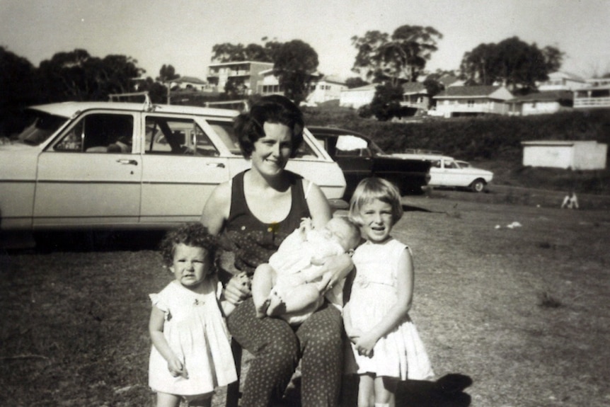 A b&w photo of Heather Winchester with her three kids. 
