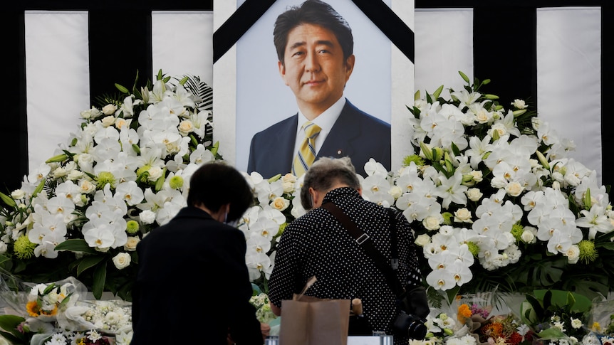 Mourners offer flowers at the altar outside Nippon Budokan Hall.