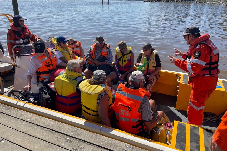 People wearing life vests sitting in small boat