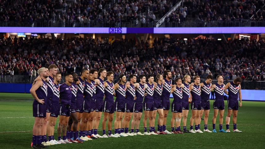 Fremantle players line up during Cam McCarthy tribute