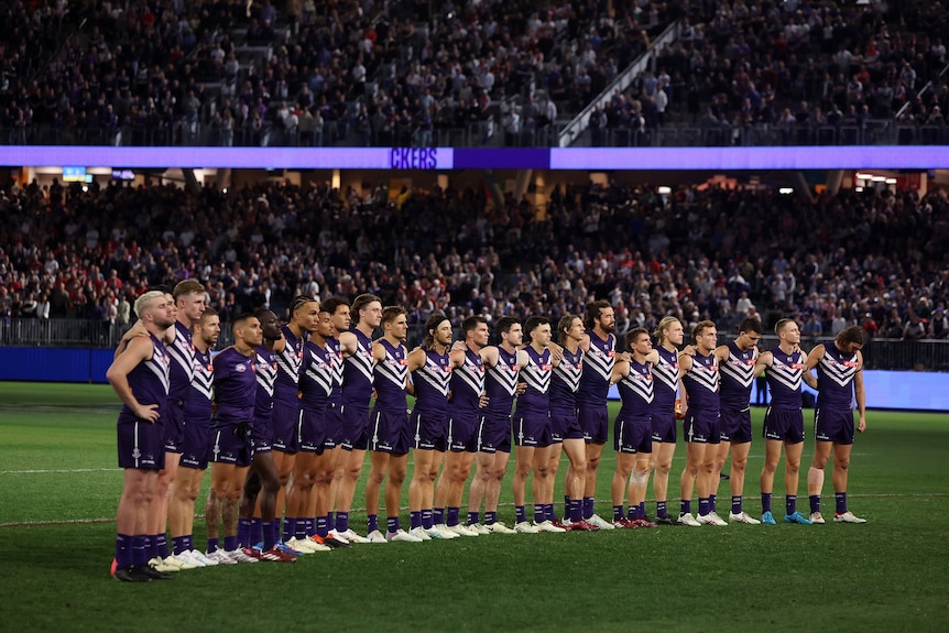 Fremantle players line up during Cam McCarthy tribute