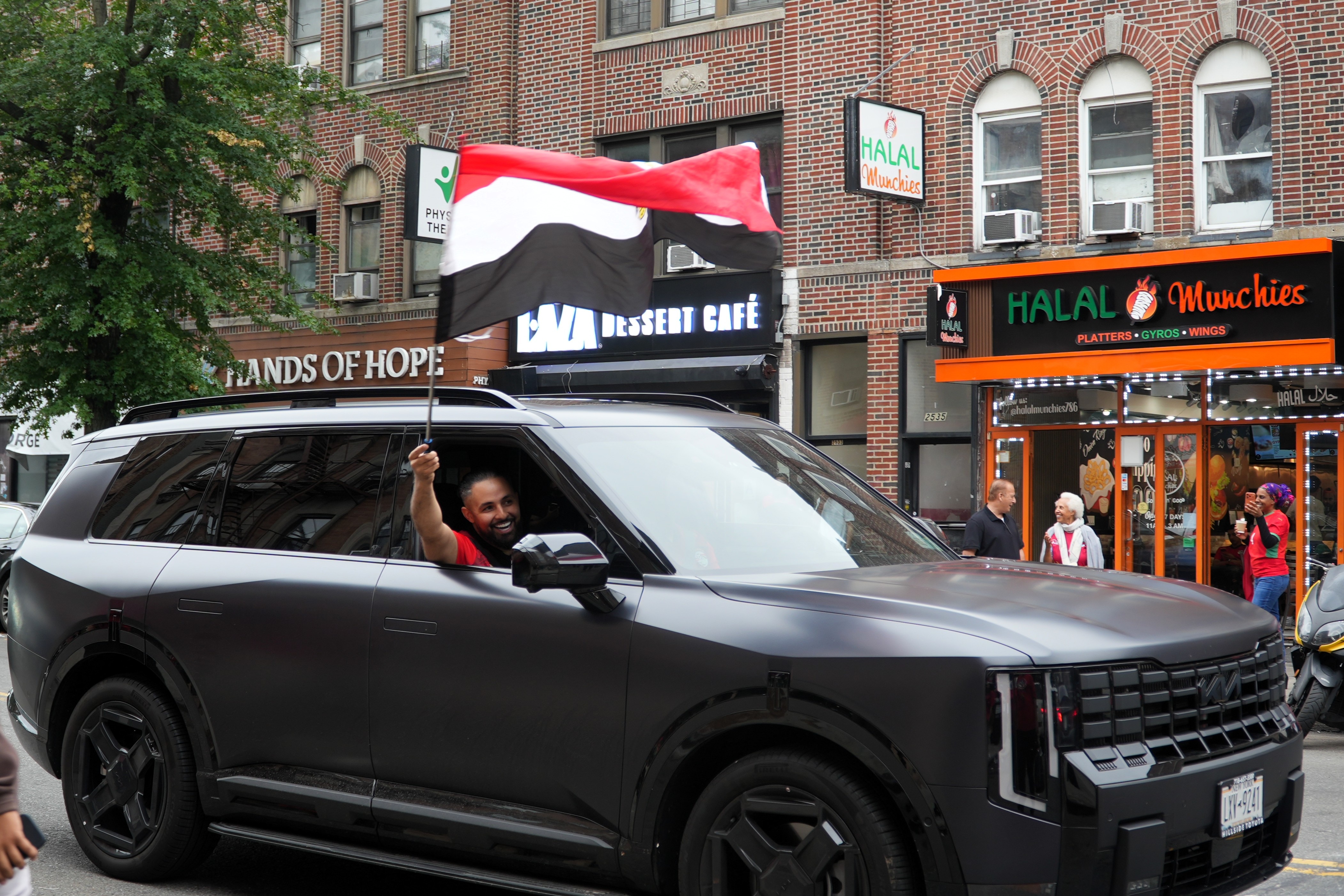 A man in a car waves an Egypt flag out the window