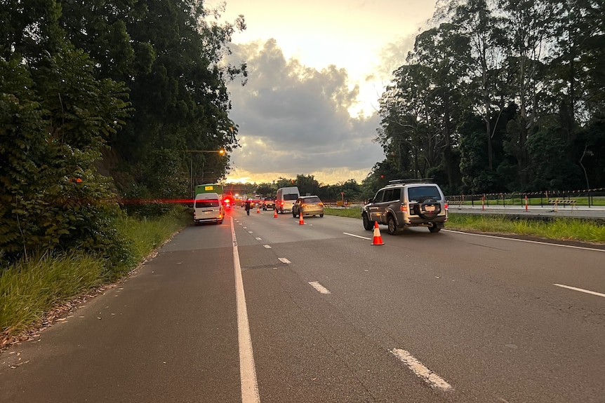 A line of cars along a closed lane of a regional highway