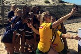 Jillaroos pose with local schoolgirls in Cronulla on Wanda Beach, August 8, 2017.