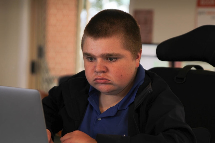 High school student Jack Wason in a wheelchair using a laptop