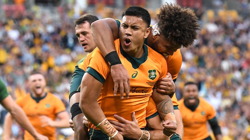 Two Wallabies players embrace as they celebrate scoring a try against the Springboks.