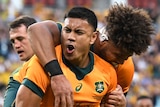 Two Wallabies players embrace as they celebrate scoring a try against the Springboks.