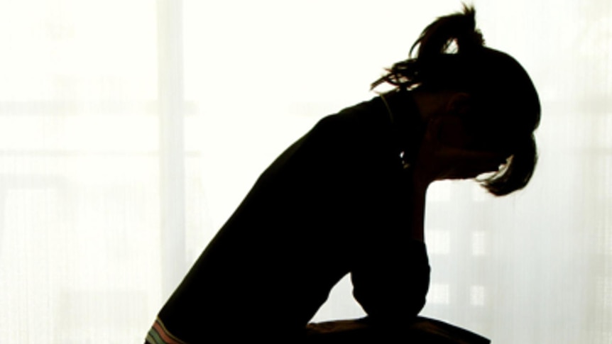 Silhouette of a woman with head in hands