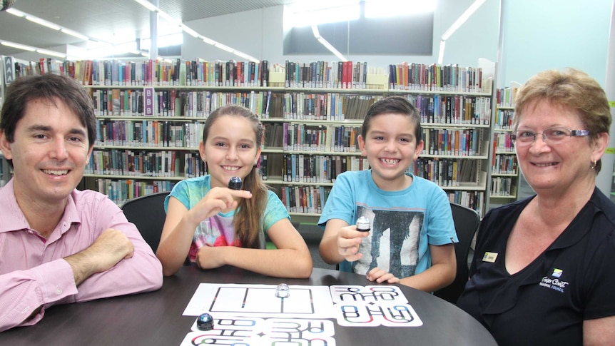 Caitlin and Samuel Stoneley holding robots at the library, with Councillor George Seymour and Jenny Campbell