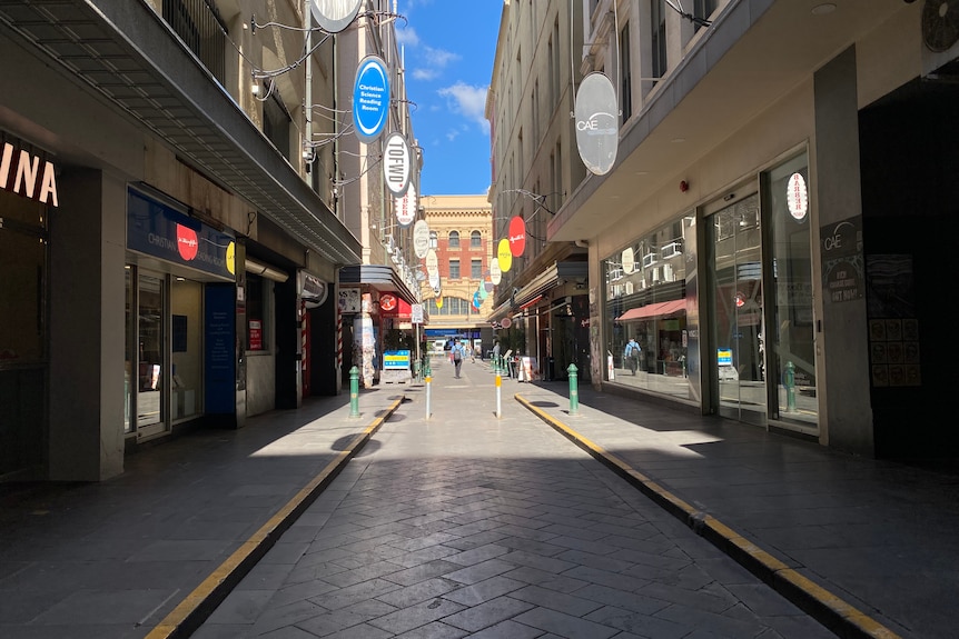 A view down Degraves Street facing Flinders Street Station, on a clear blue sunny day.