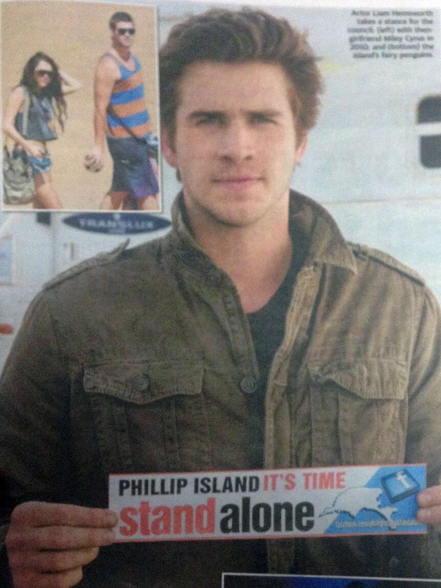 Actor Liam Hemsworth holds up a "Phillip Island: It's time to stand alone" sign for the Herald Sun