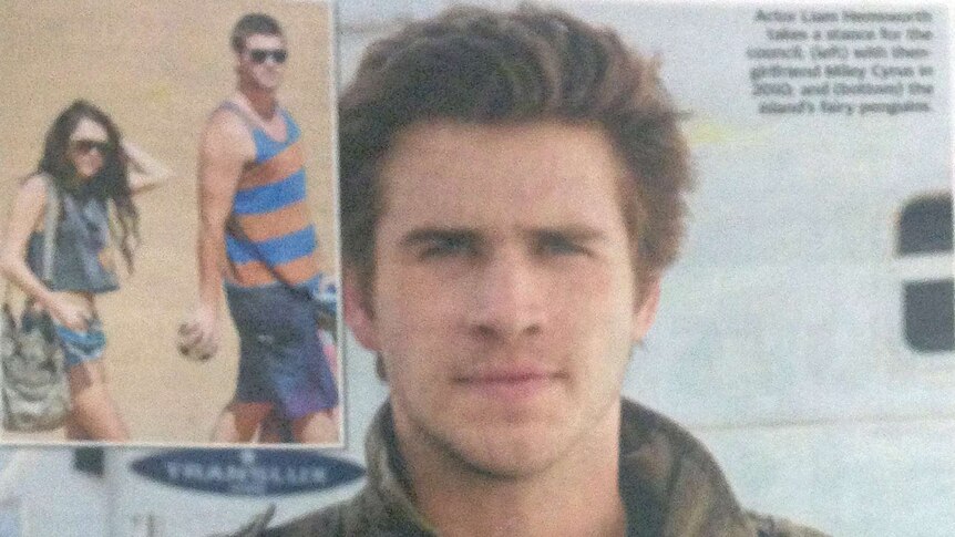 Actor Liam Hemsworth holds up a "Phillip Island: It's time to stand alone" sign for the Herald Sun