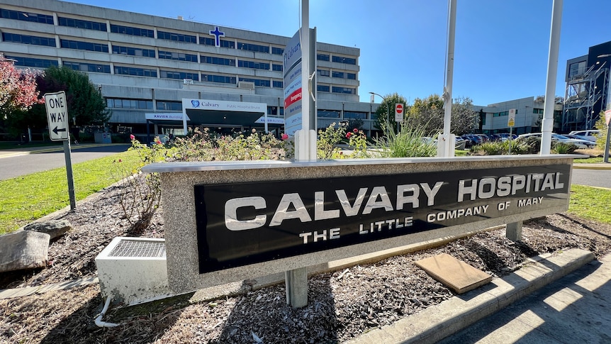 A sign that says Calvary Hospital on a sunny day. 