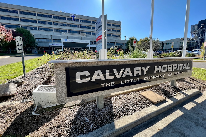 A sign that says Calvary Hospital on a sunny day. 