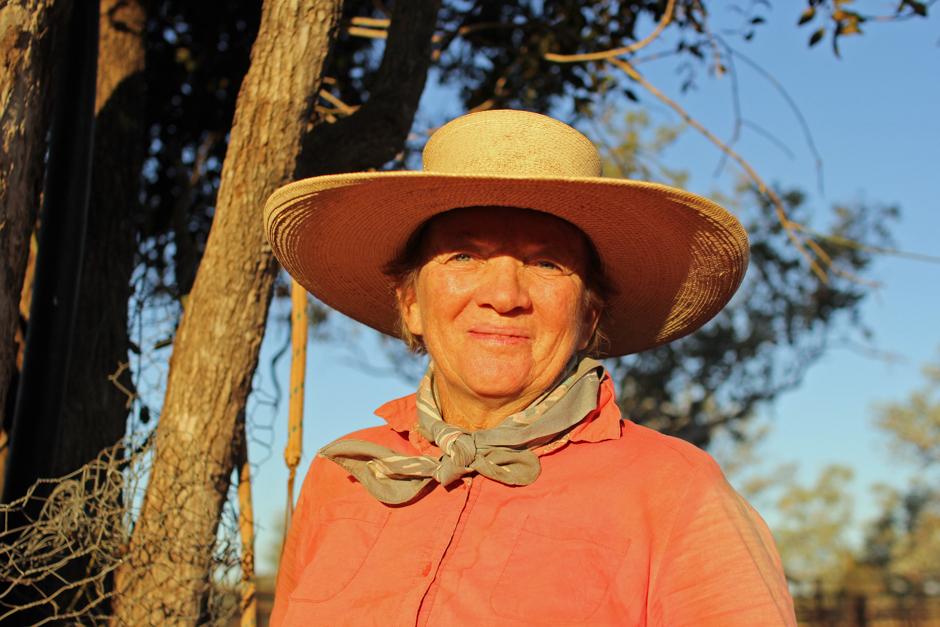 A woman in a broad-brimmed straw hat with a bandanna tied loosely around her neck.