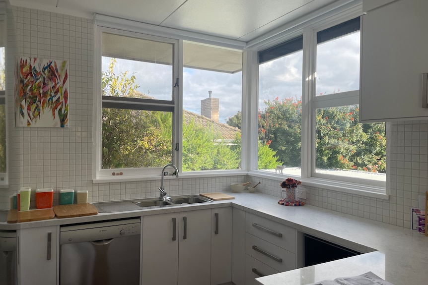 White painted kitchen with large corner windows 