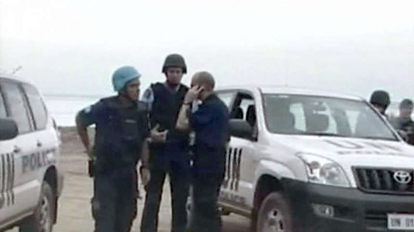 Police and UN soldiers man a roadblock in Dili.