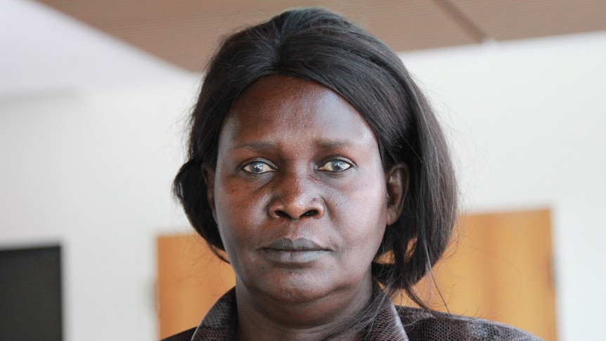 Mother of Liep Gony, Martha Alama Ojulo, looks directly into the camera in an office building.