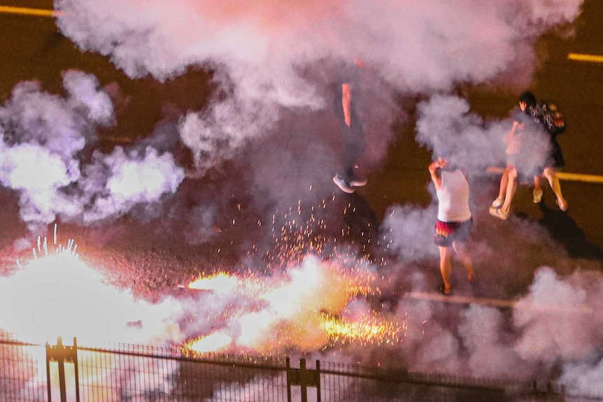 Protesters on street among smoke from grenades