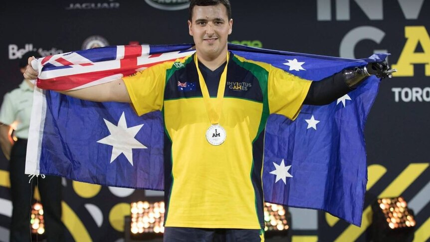 An athlete, with a prosthetic hand, with the Australian flag.