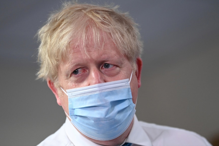 Boris Johnson wears a medical mask during a hospital visit.