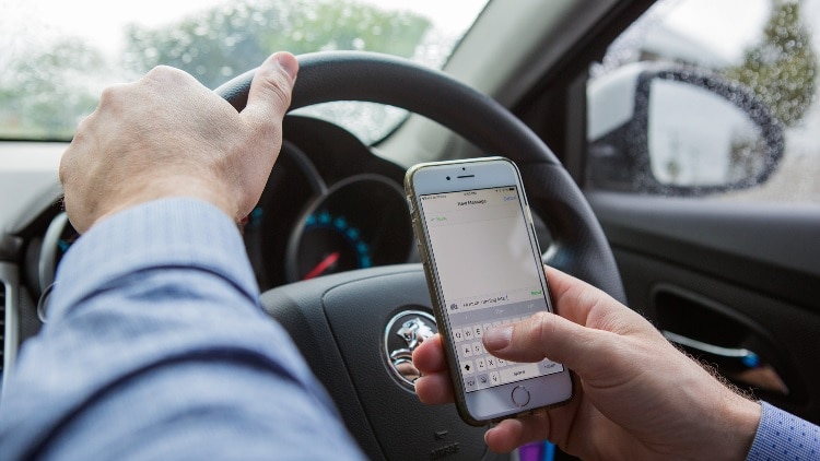 Person using a phone while driving.